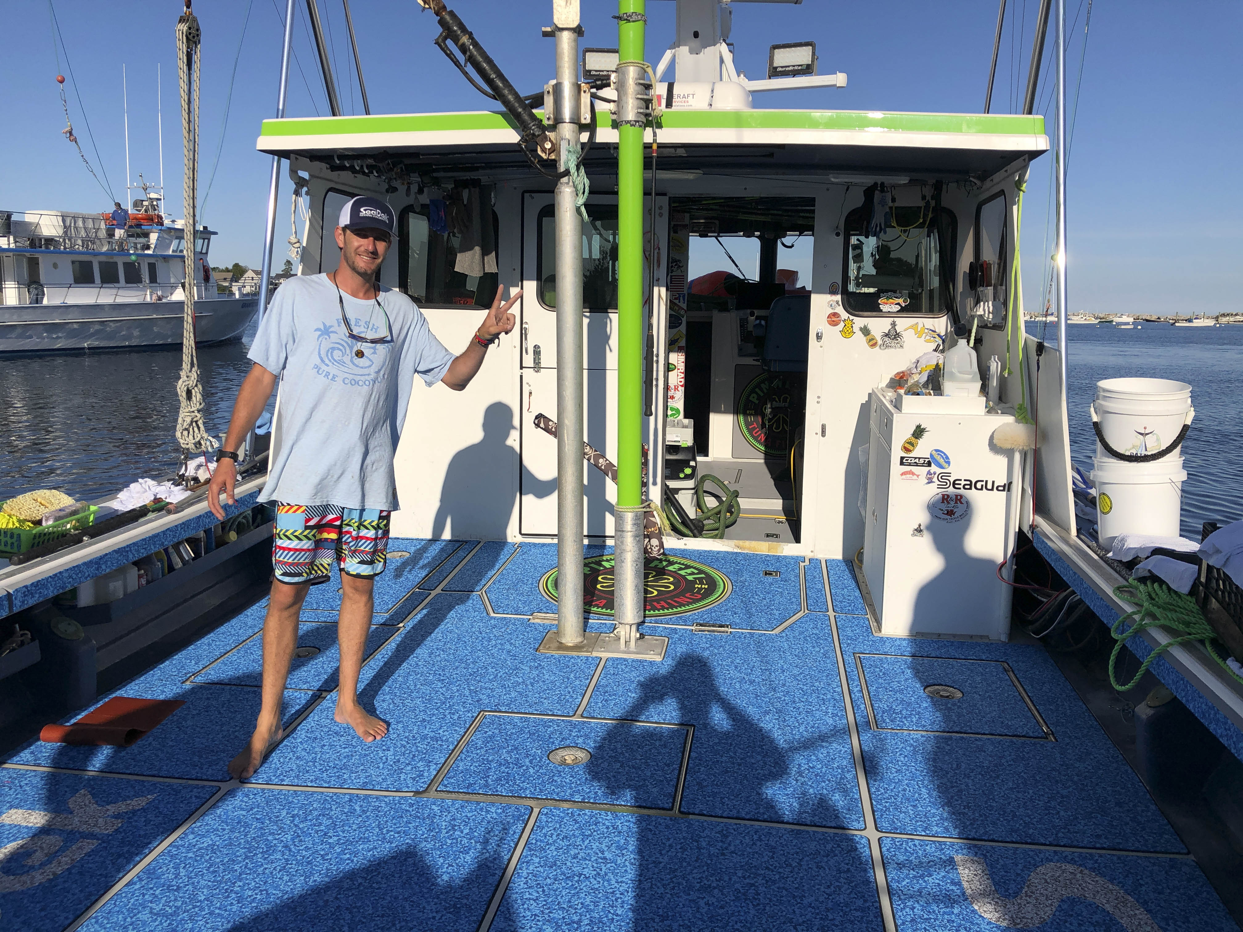 The SeaDek covered deck of the Pinwheel with one man standing on it.